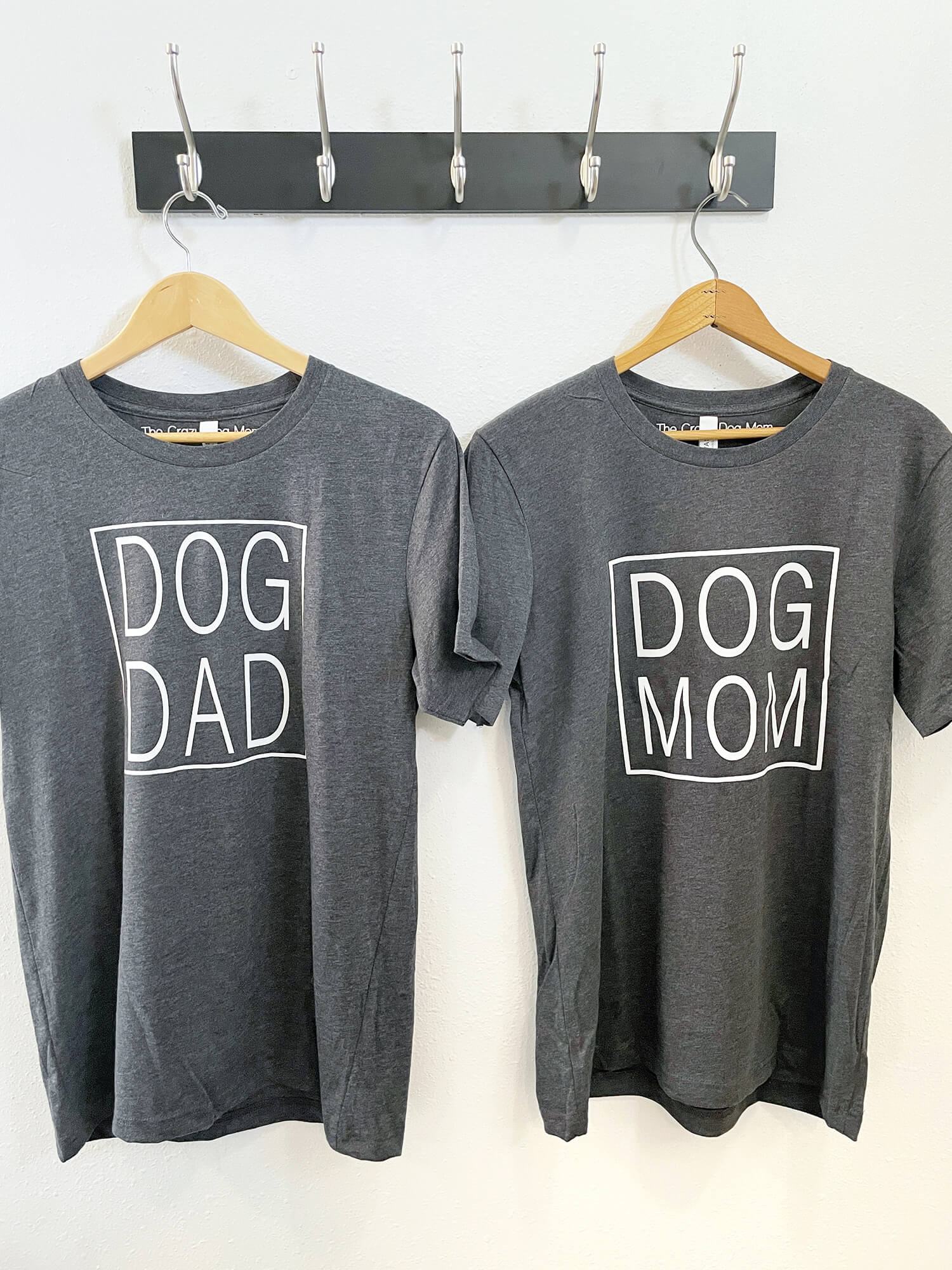 dog dad t-shirt and dog mom t-shirt hanging side by side